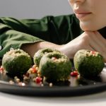 Close-up of spinach pkhali, a Georgian vegan dish, with a woman in green observing.
